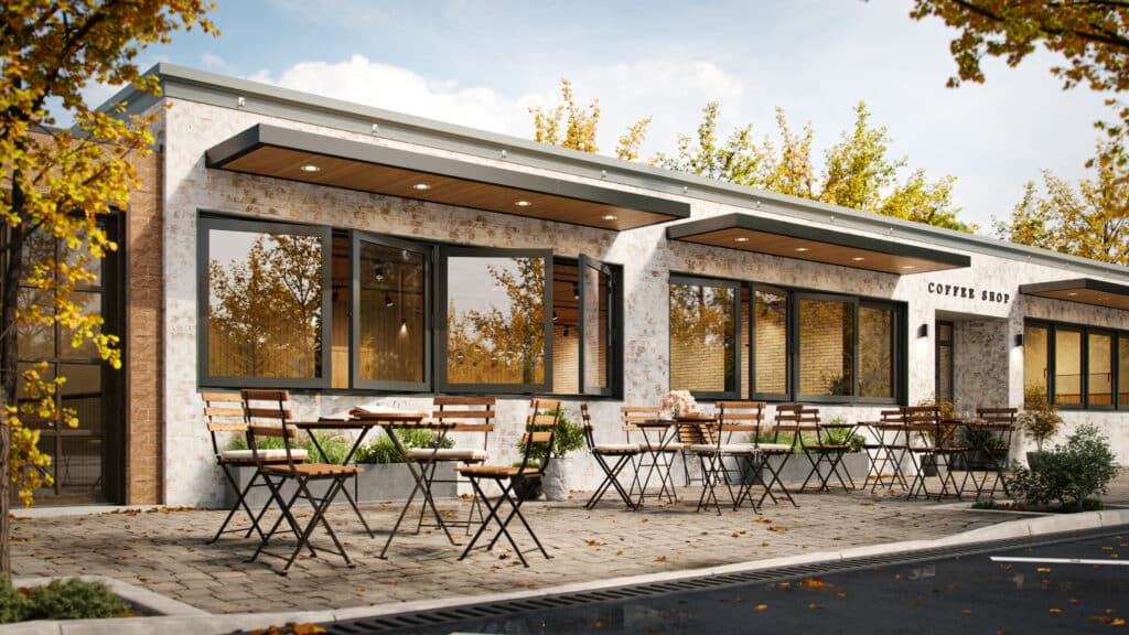 A stylish coffee shop exterior with distressed white brick, a paved patio with outdoor seating, and large operable windows that demonstrate a high-quality Storm Window Replacement.
